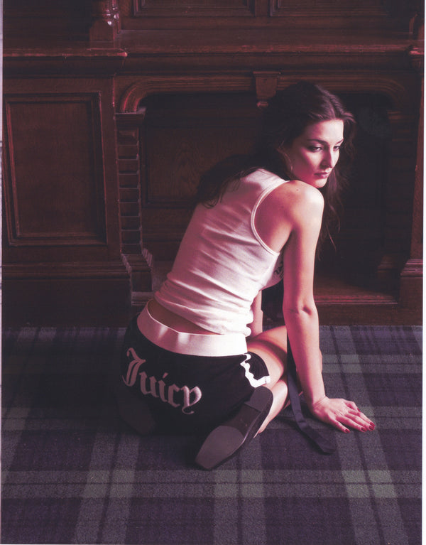Displays a model wearing the Black Appliqué 'Juicy' branded  Terry booty shorts featuring the juicy branding 