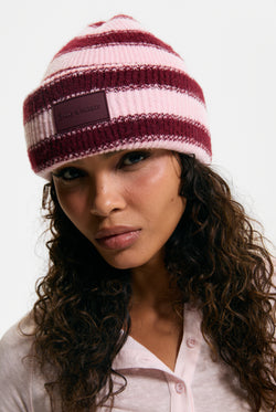 Displays a model wearing the Burgundy Stripe 'Juicy' branded Ribbed Beanie