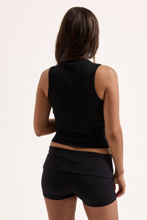 Displays a model wearing the Black 'Juicy' branded ribbed outline diamanté racer vest 