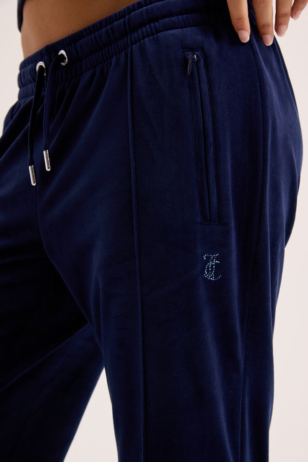 Displays a model wearing the Night Sky outline 'Juicy' branded velour diamanté tracksuit bottom 