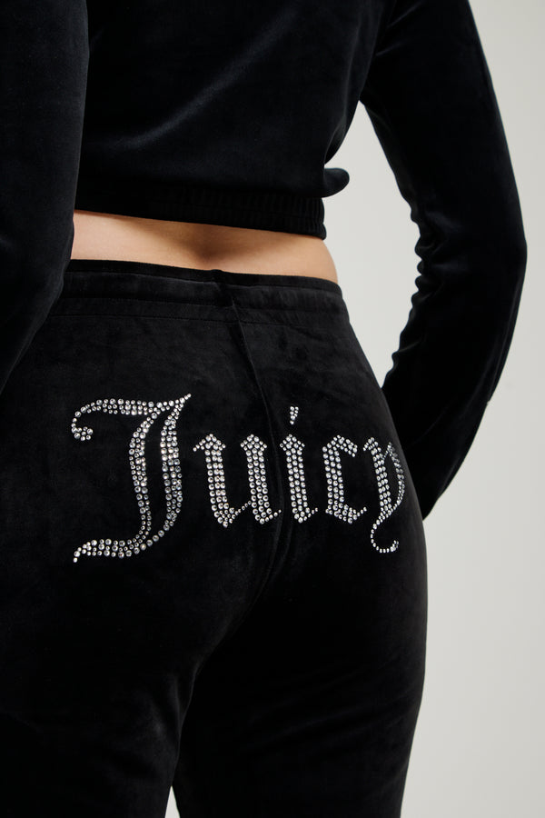 Black sweatpants with 'Juicy' text in rhinestones on a neutral background