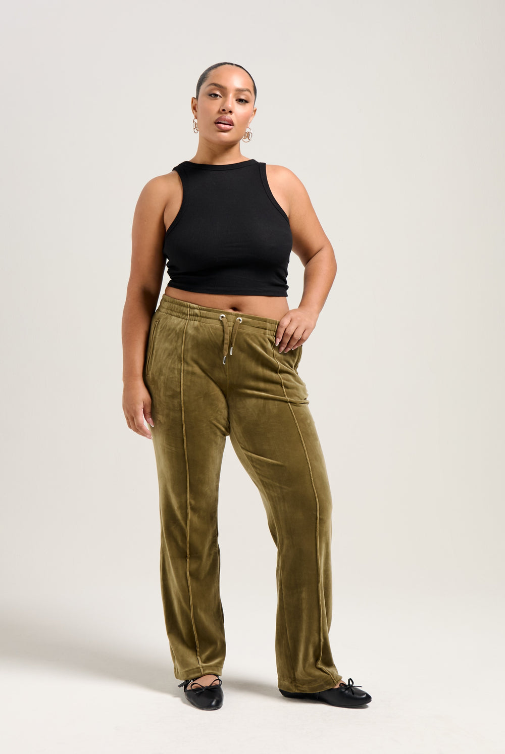 Displays a model wearing the Dark Olive 'Juicy' branded velour diamanté tracksuit bottom