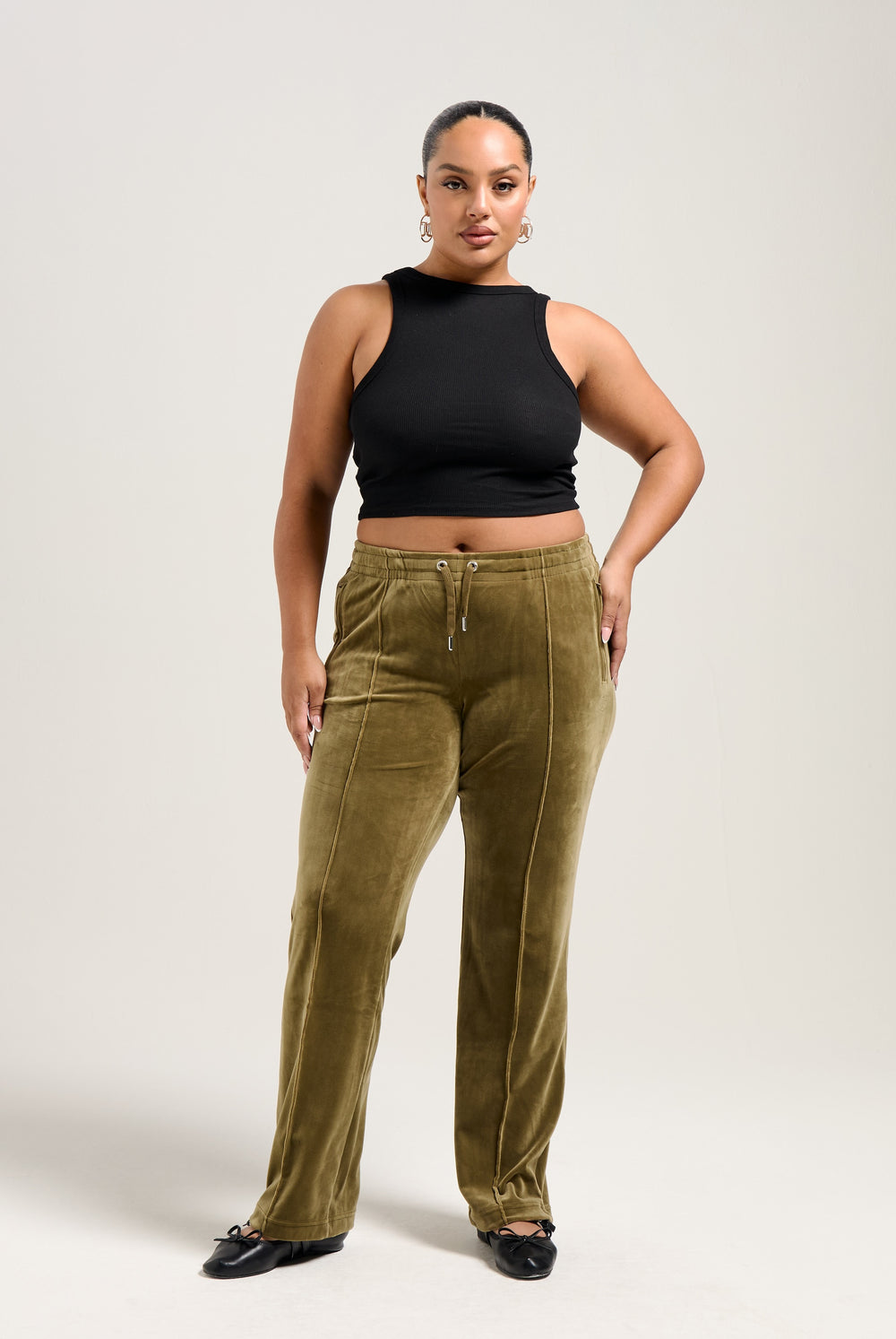 Displays a model wearing the Dark Olive 'Juicy' branded velour diamanté tracksuit bottom