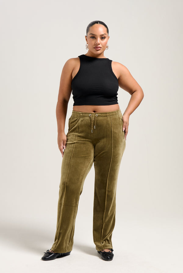 Displays a model wearing the Dark Olive 'Juicy' branded velour diamanté tracksuit bottom