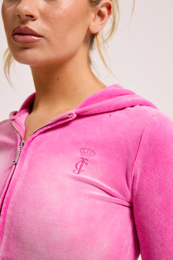 Displays a model wearing the super pink washed 'juicy' branded cotton velour fitted hoodie 