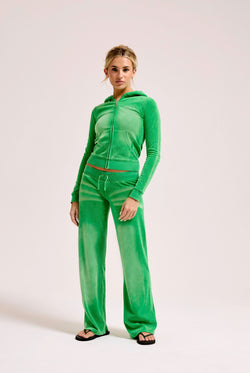 Displays a model wearing the Jolly Green washed 'Juicy' branded OG straight track pant 