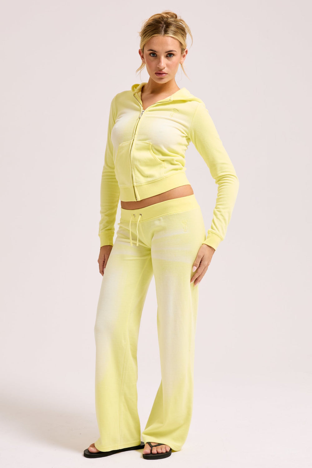 Displays a model wearing the Yellow pear washed 'Juicy' branded OG straight track pant 