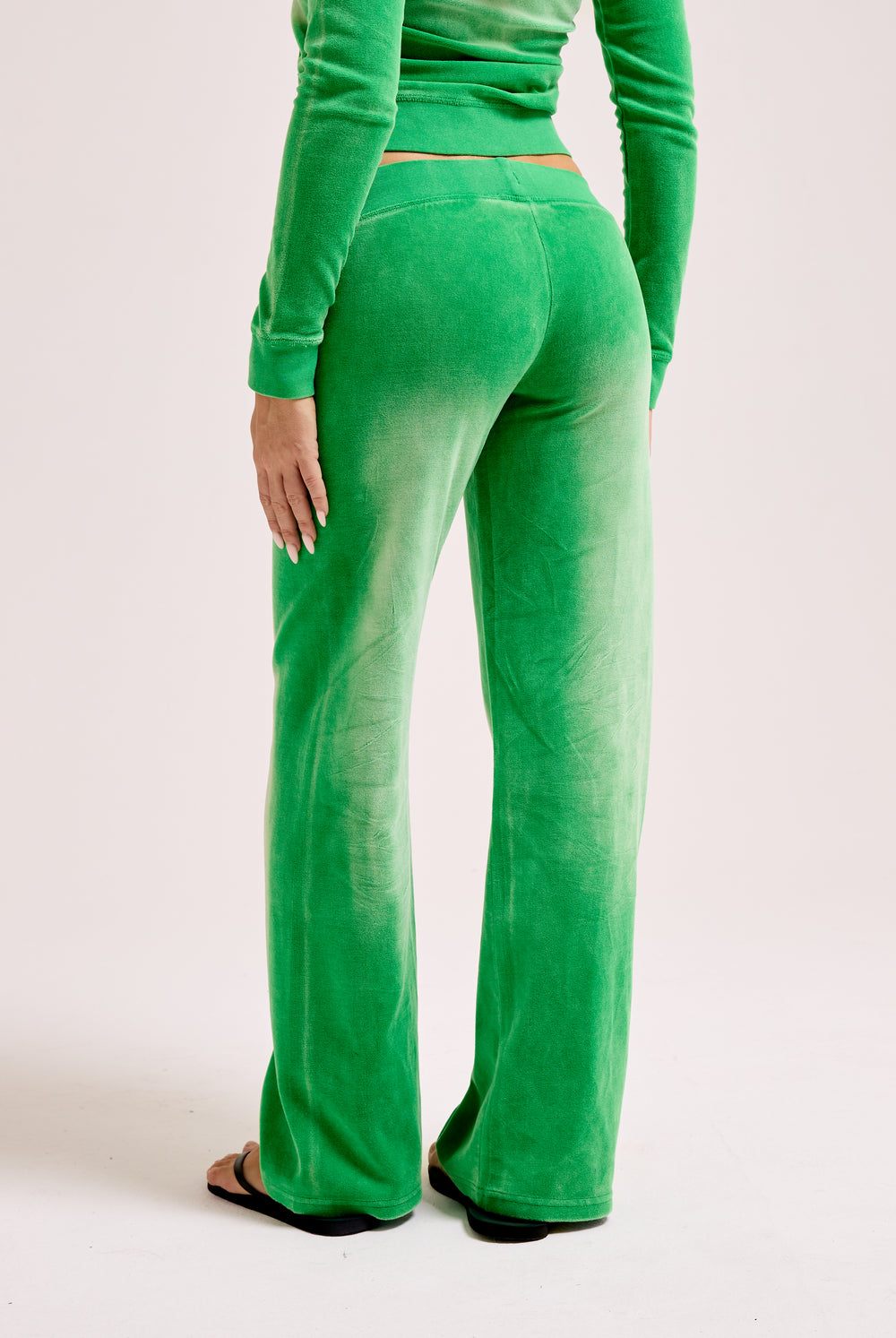 Displays a model wearing the Jolly Green washed 'Juicy' branded OG straight track pant 