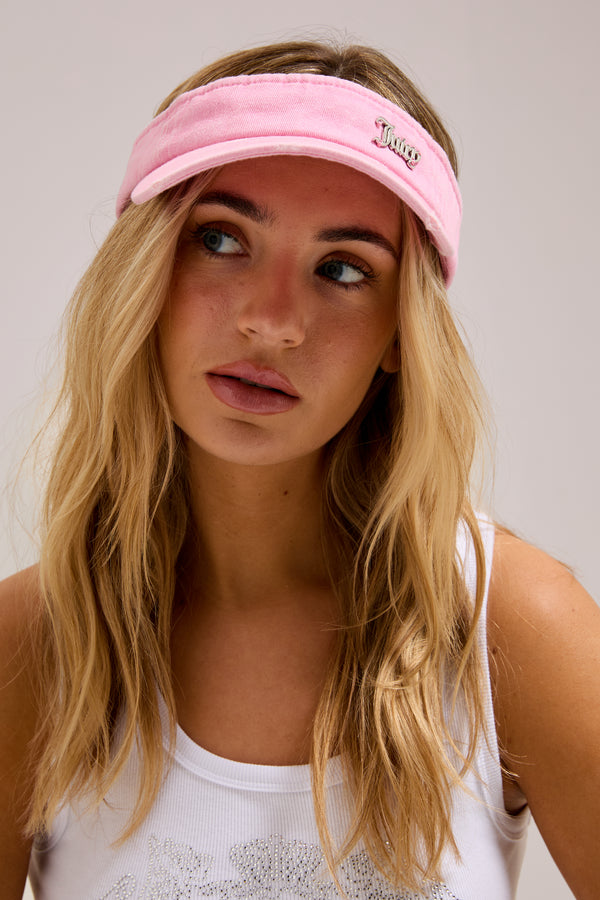 Displays a model wearing the pink distressed 'juicy' branded cotton denim visor  