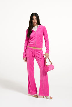 Displays a model wearing the Nostalgia Pink 'Juicy' branded Washed Caisa Ultra Low Rise Pant
