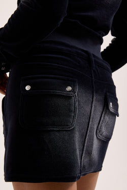 Displays a model wearing the Washed Black 'Juicy' branded Cotton velour mini skirt 