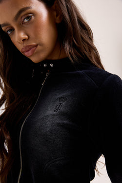 Displays a model wearing the washed black 'juicy' branded cotton velour moto jacket