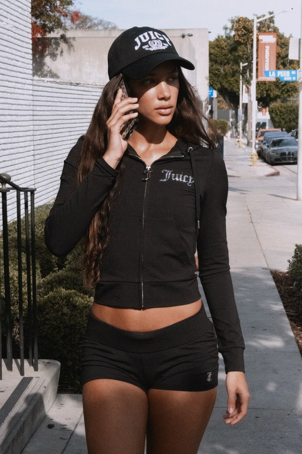 Displays a model wearing the Black 'Juicy' branded diamanté luxury jersey zip-through hoodie
